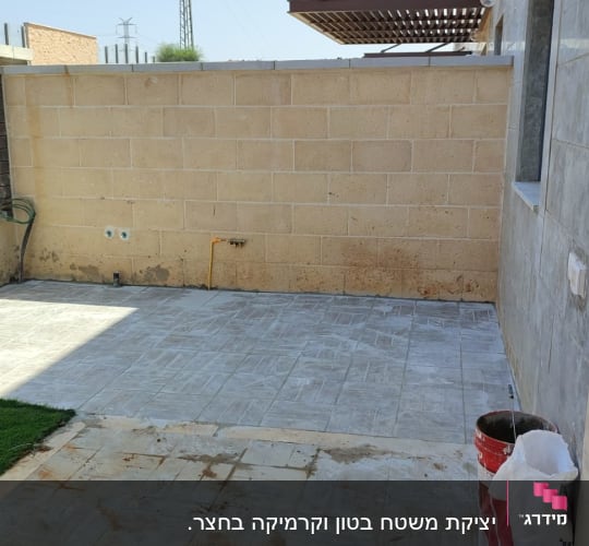 ריצוף חדש בחצר עם קיר בלוקים וגדר מתכת